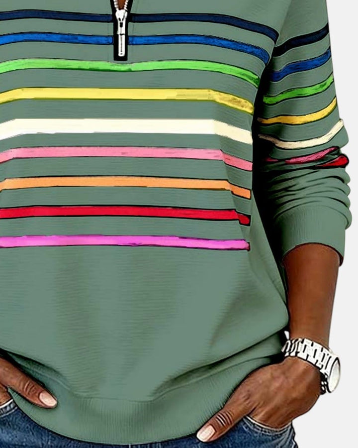 Woman zipping up rainbow striped sweatshirt showing easy front zip functionality