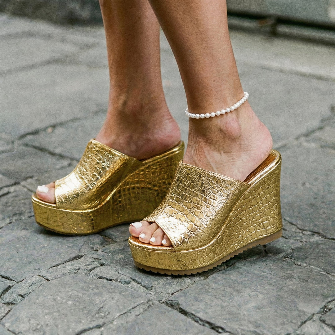 Isadora gold platform wedge sandals shown from the front on a white background