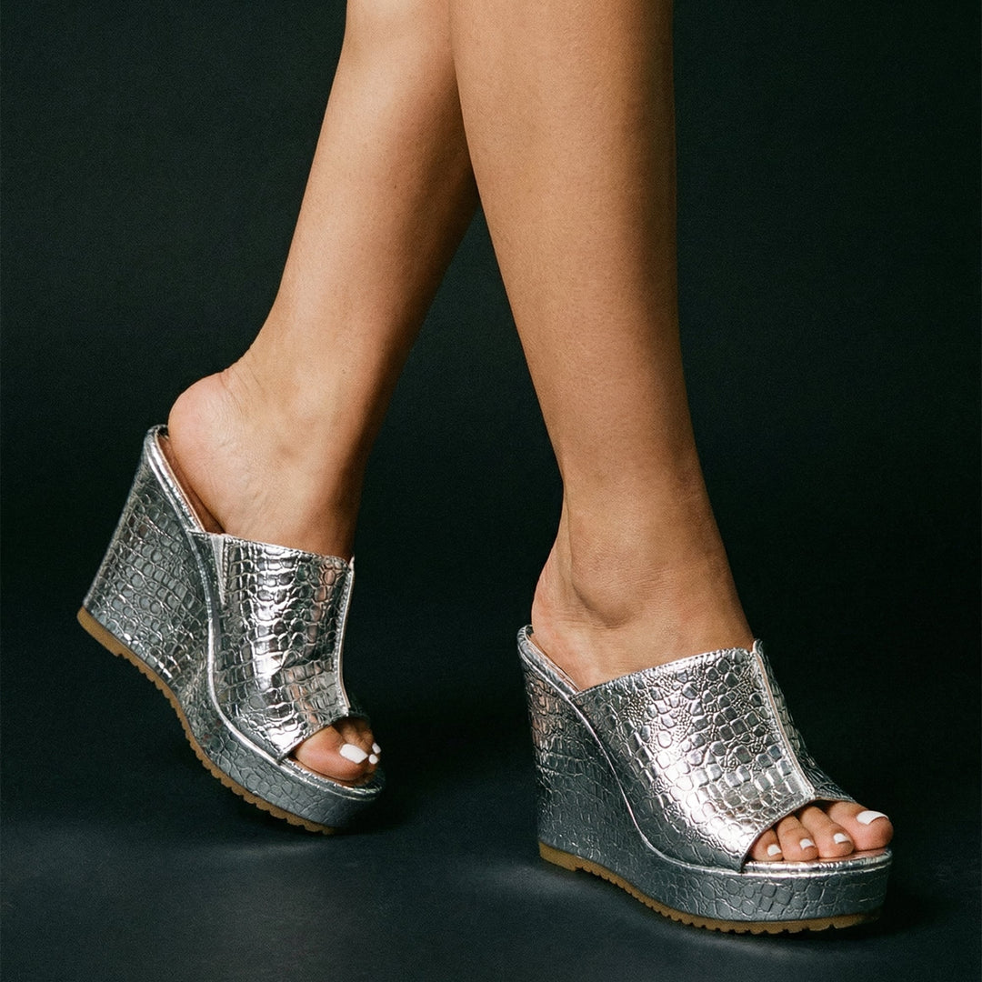 Lifestyle shot of Isadora gold platform wedge sandals styled with a flowy summer dress