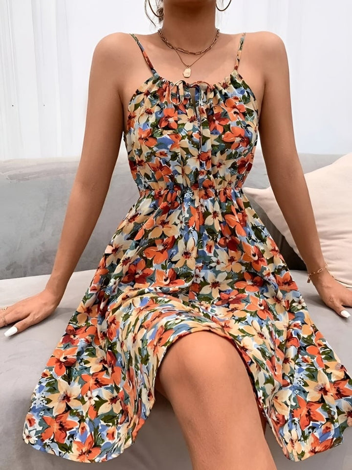 Woman wearing a pink floral halter summer dress with A-line silhouette and lace-up neckline detail