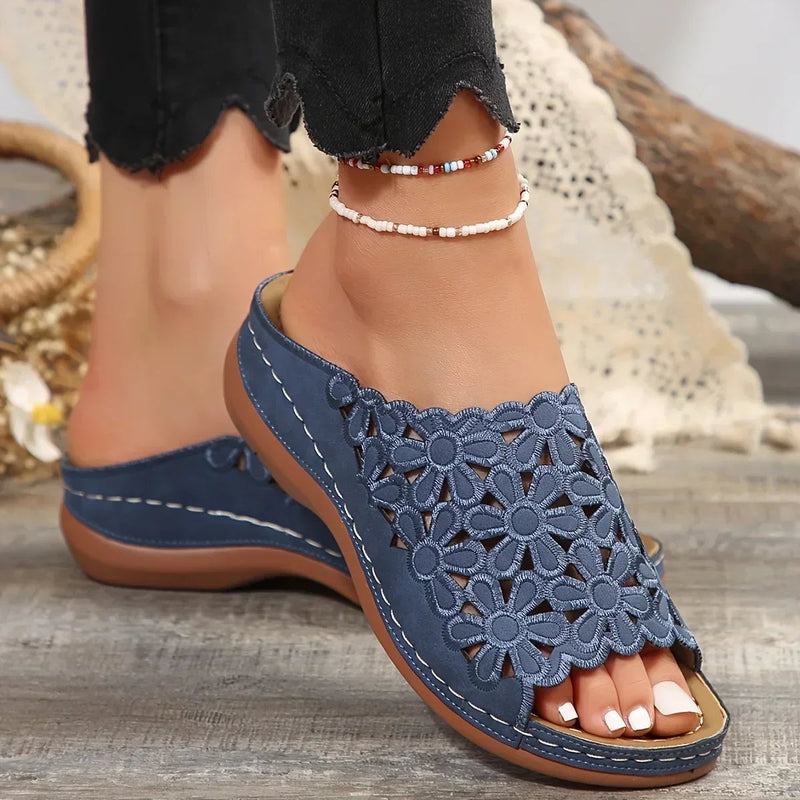 Top-down view of Isla floral sandals in blue on a neutral background