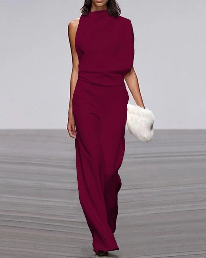 Model wearing ivory wide-leg jumpsuit styled with strappy heels and gold jewelry