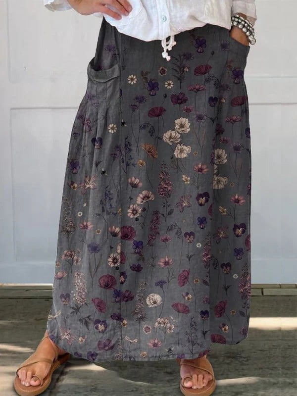 Black floral art print A-line midi skirt with side pockets and elastic waistband, shown in full length