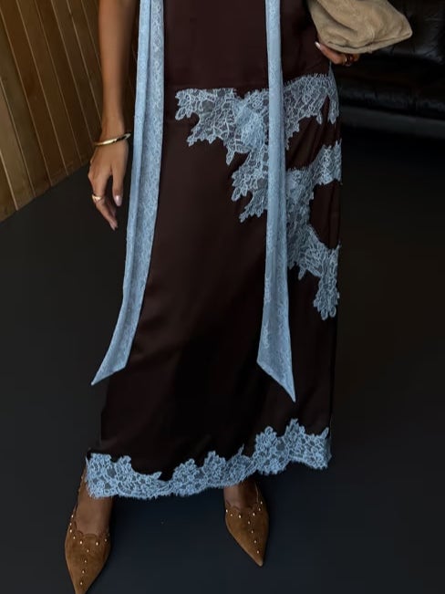 Model showcasing the brown and blue lace top and skirt set at a three-quarter angle
