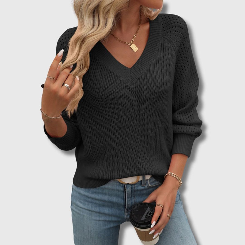Model in a black V-neck sweater styled with trousers for a polished, put-together look