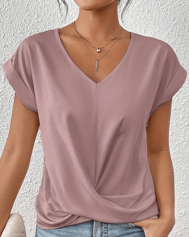 Back view of a woman wearing a white V-neck twist front short sleeve top
