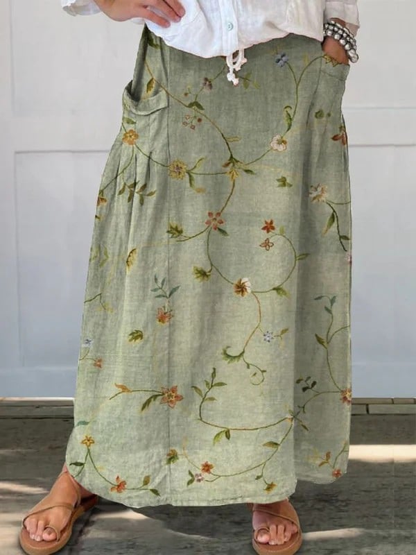 Sage green retro floral A-line skirt with elastic waistband and side pockets, shown on a model