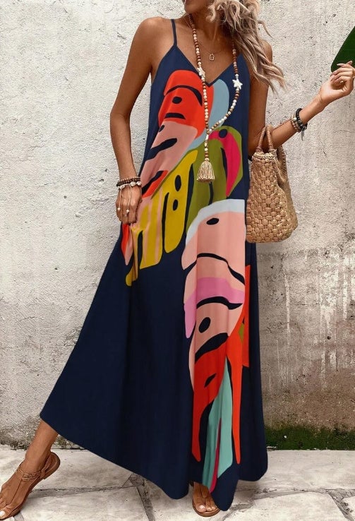 Woman wearing a navy blue leaf print maxi dress, full-length side view showing relaxed flowing fit