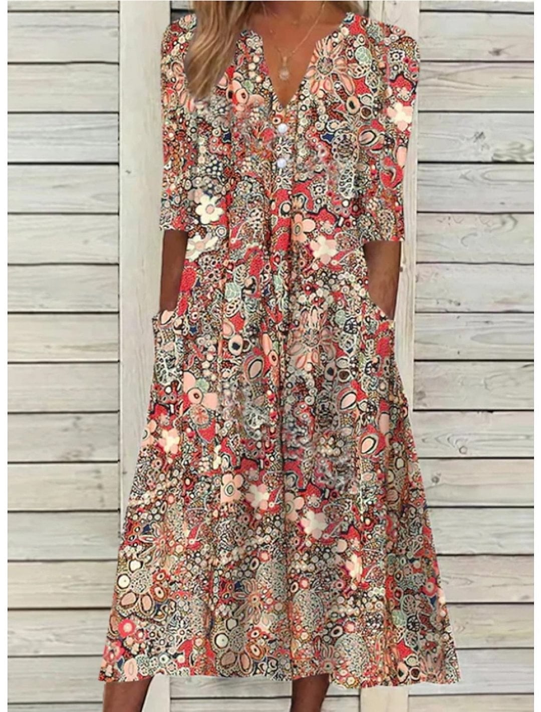 Woman wearing a flowy red V-neck summer dress with flattering tummy-coverage draping, styled for a warm-weather outing