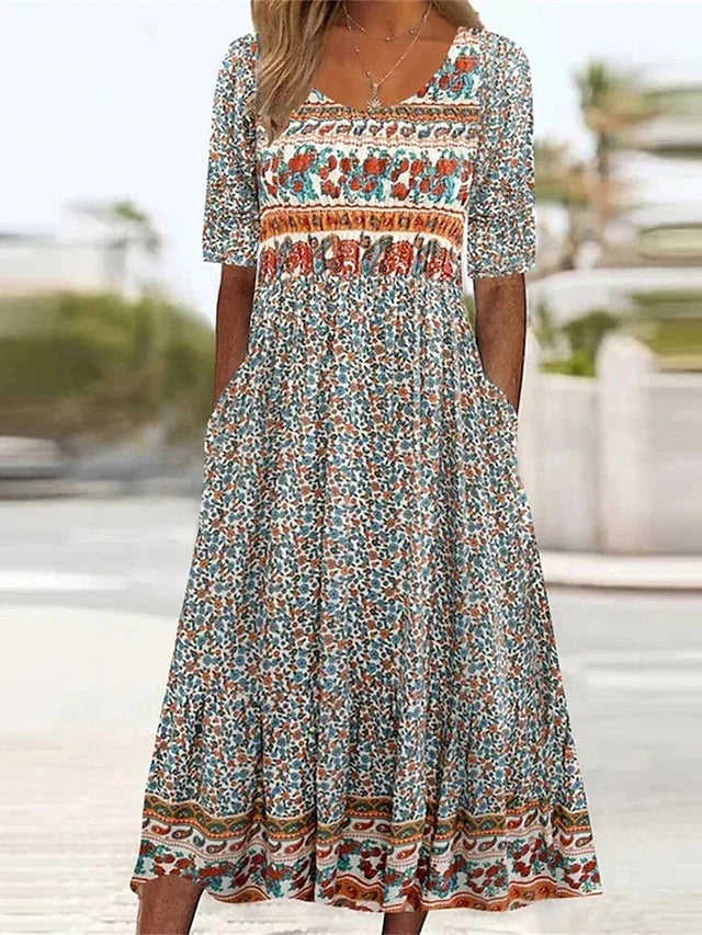 Model wearing a flowing bohemian print dress with round neckline in multicolor pattern, front view
