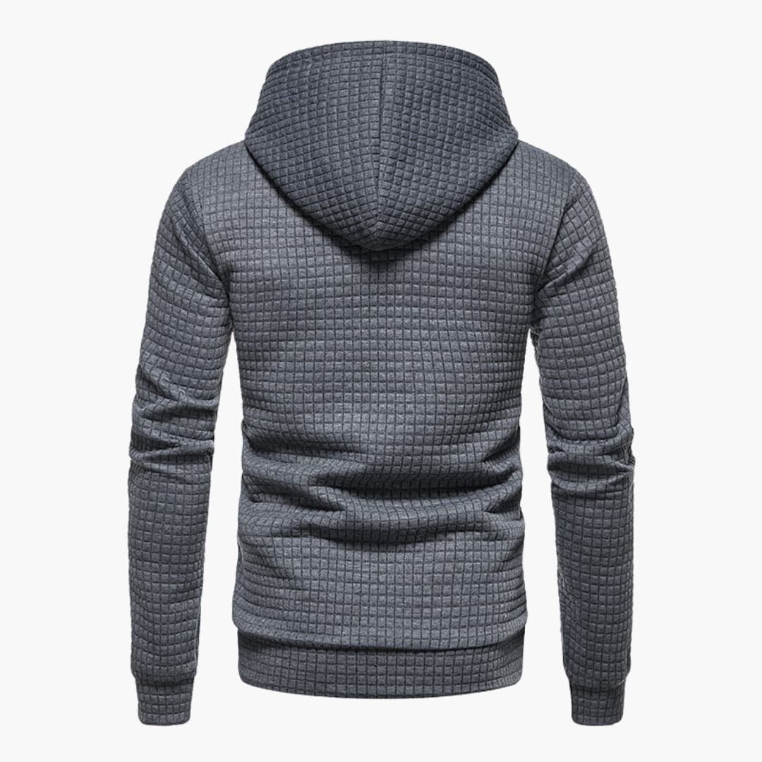 Model wearing the dark grey Jasper Comfort Hoodie in a relaxed seated pose