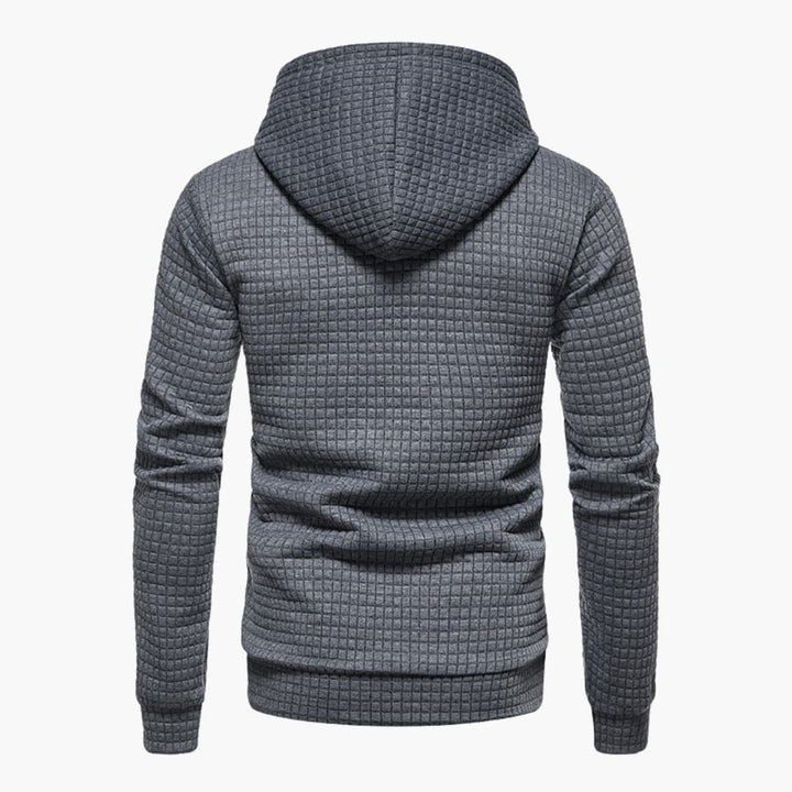 Model wearing the dark grey Jasper Comfort Hoodie in a relaxed seated pose