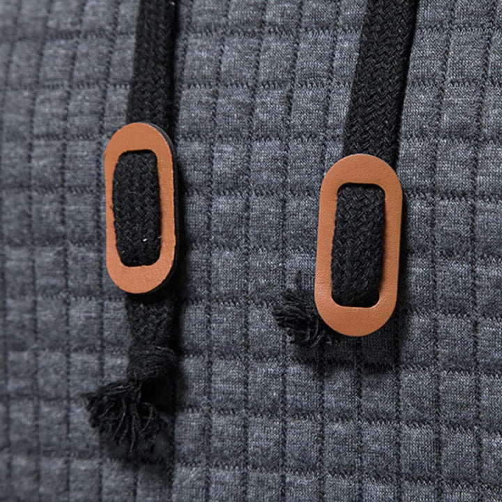 Detail of the checkered print on the dark grey Jasper Comfort Hoodie