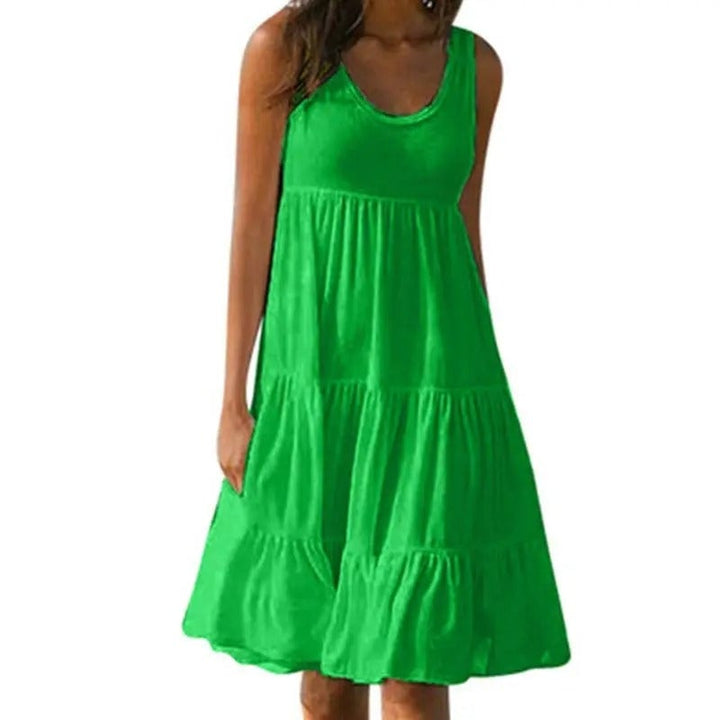 Woman wearing a green sleeveless solid bodycon dress with an open back and subtle hem split