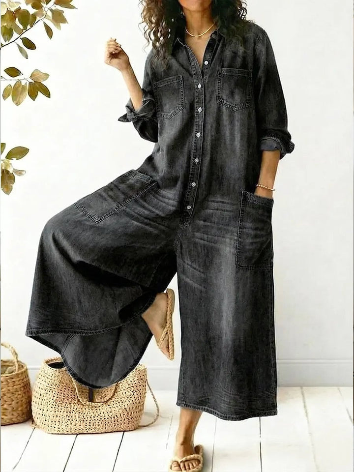 Front detail of the Jeen jumpsuit showing the point collar, button-front placket, and dual chest pockets in blue