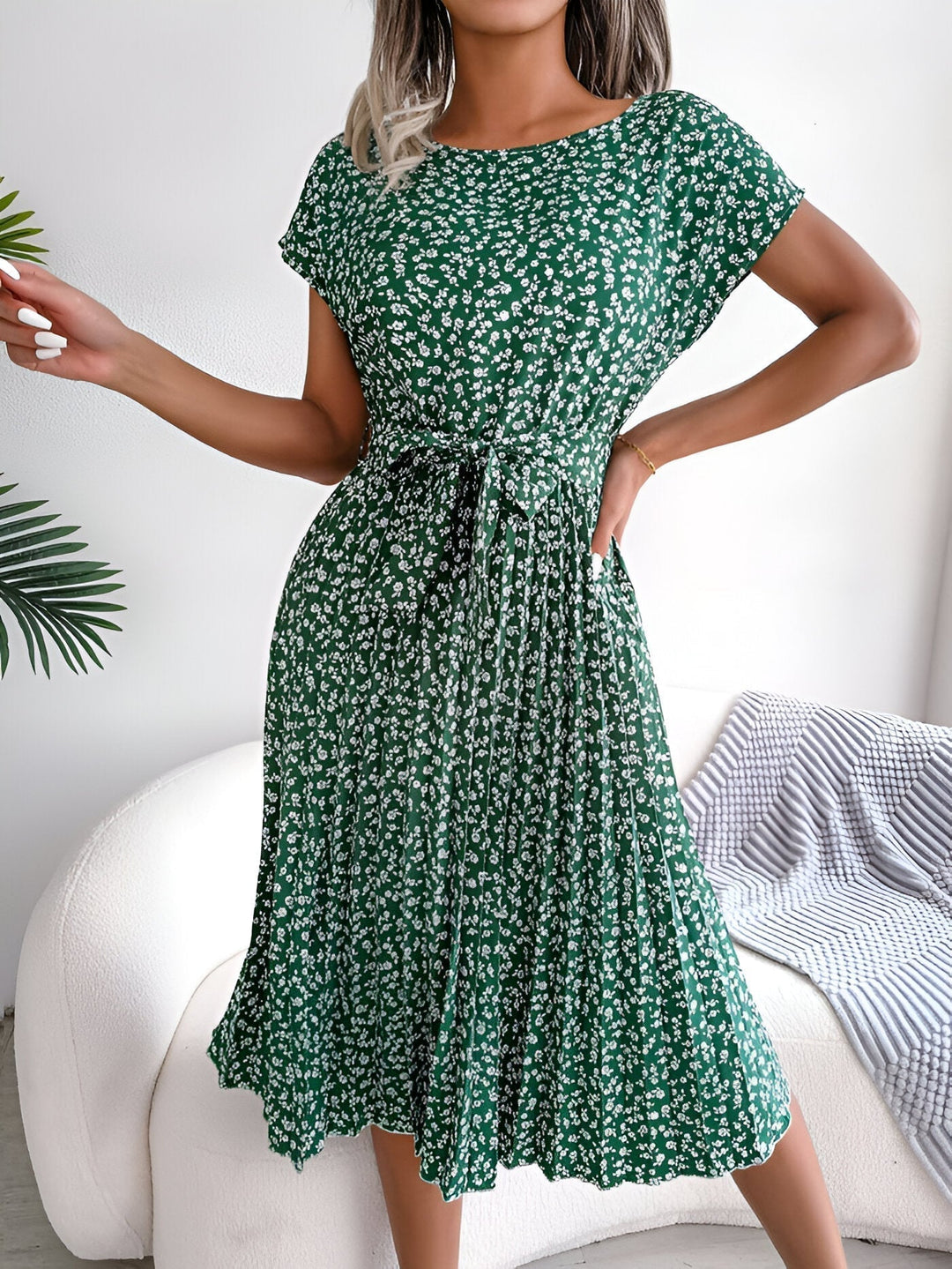 Model wearing a floral pleated A-line dress with short sleeves in Lotus Pink, shown from the front