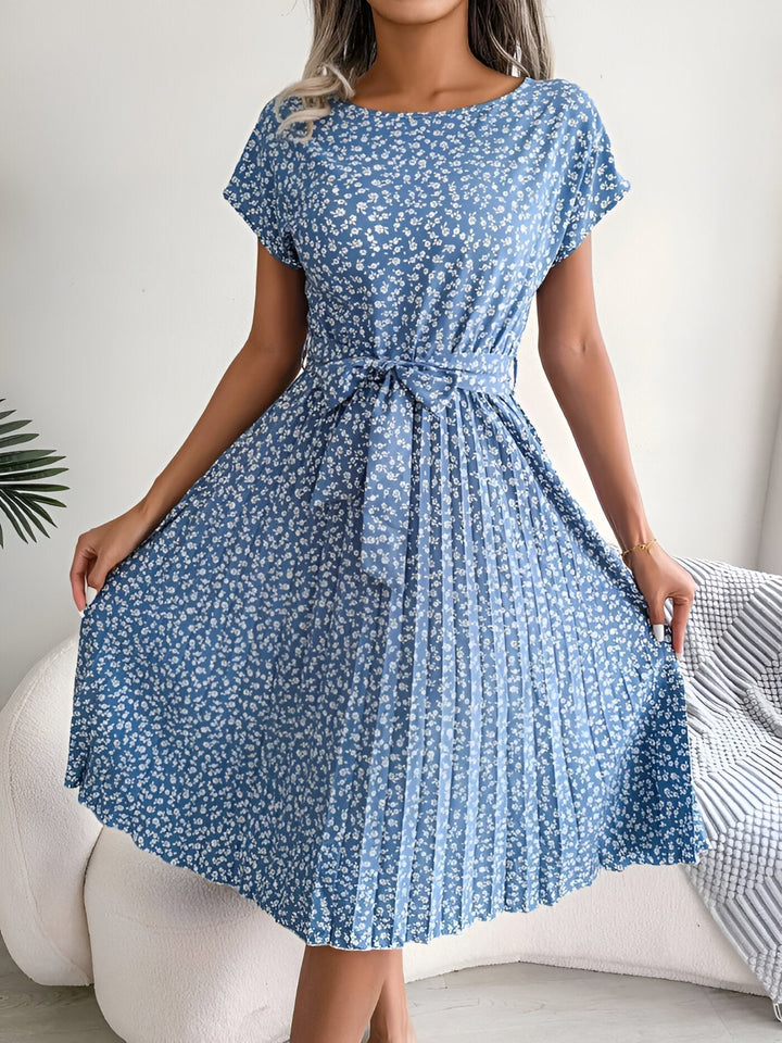 Close-up detail of the soft pleated skirt and vibrant floral print on the A-line dress