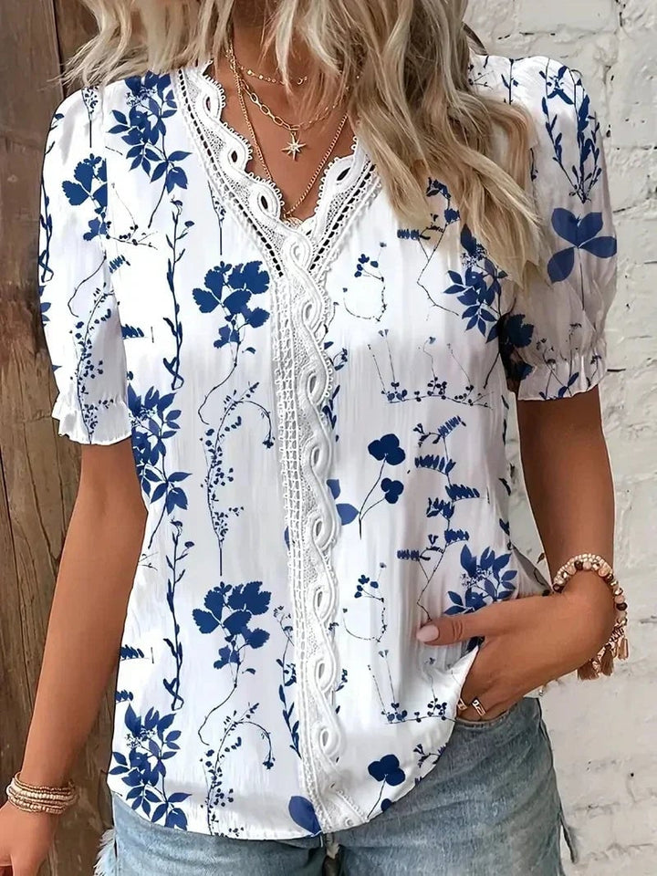 Close-up of delicate floral lace detailing on a V-neck blouse in light blue
