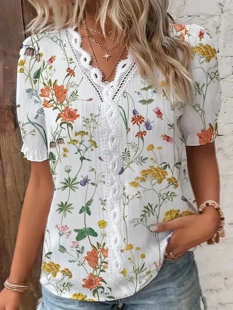 Orange floral lace V-neck blouse shown on a model, highlighting the flattering silhouette