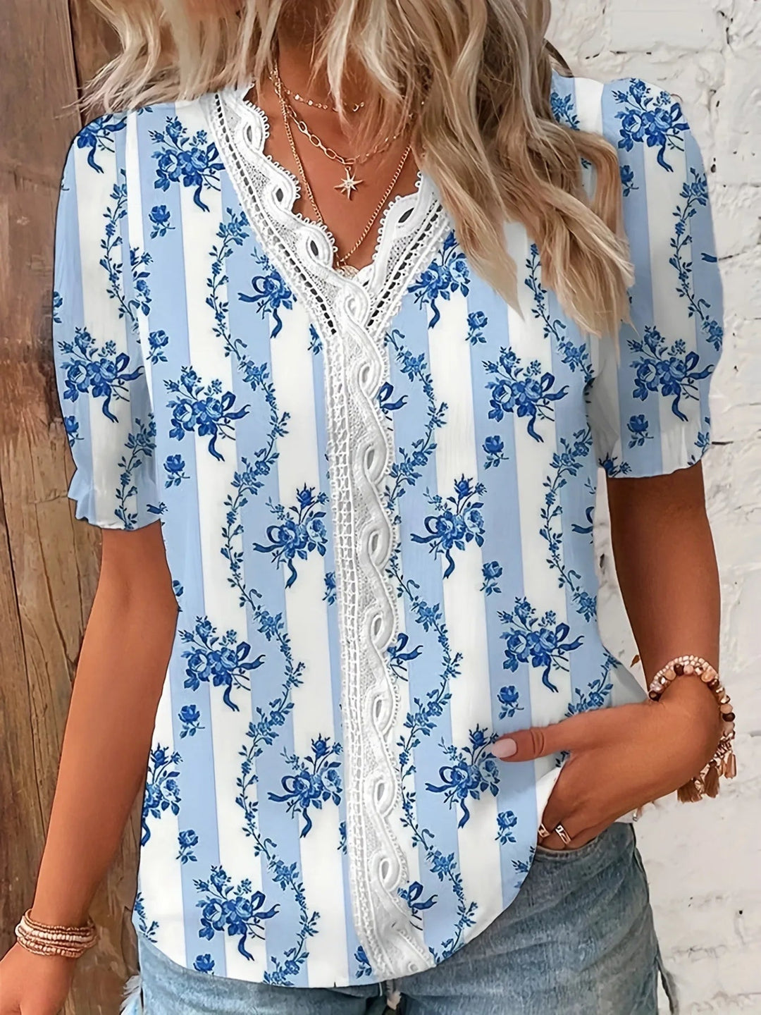 Dark blue floral lace V-neck blouse displayed on a model, side angle view