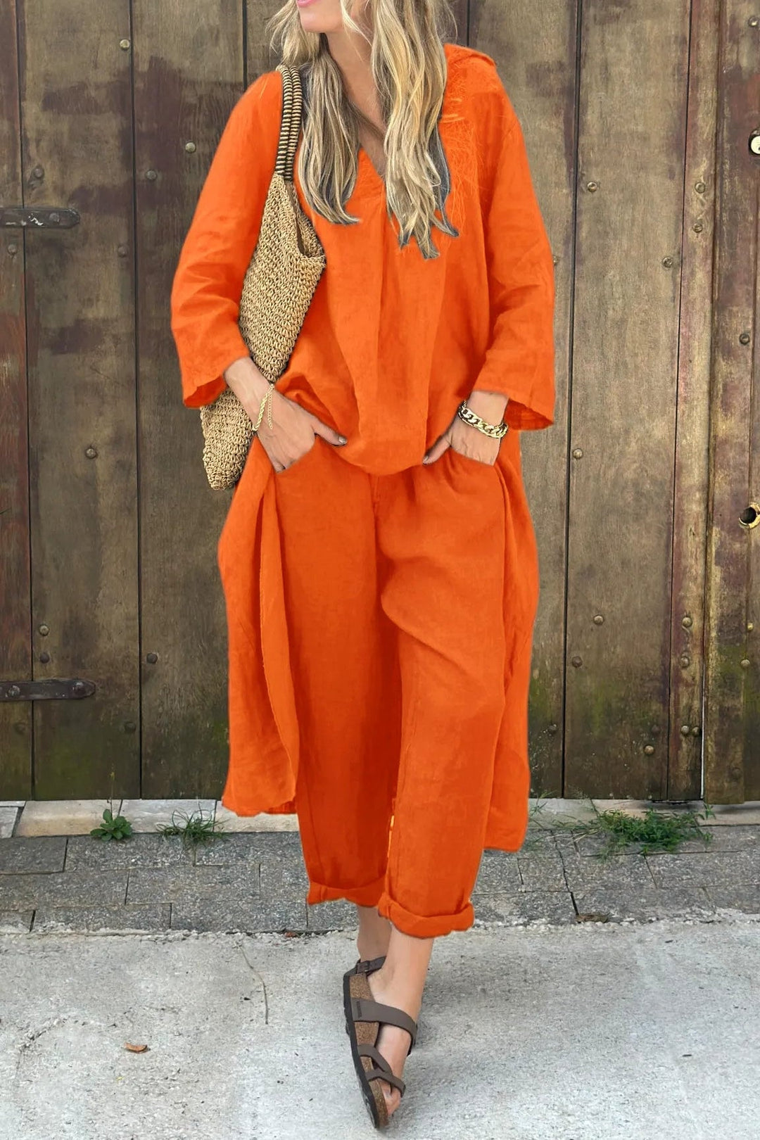 Styled flat lay of the matching set in orange showing both top and bottoms pieces
