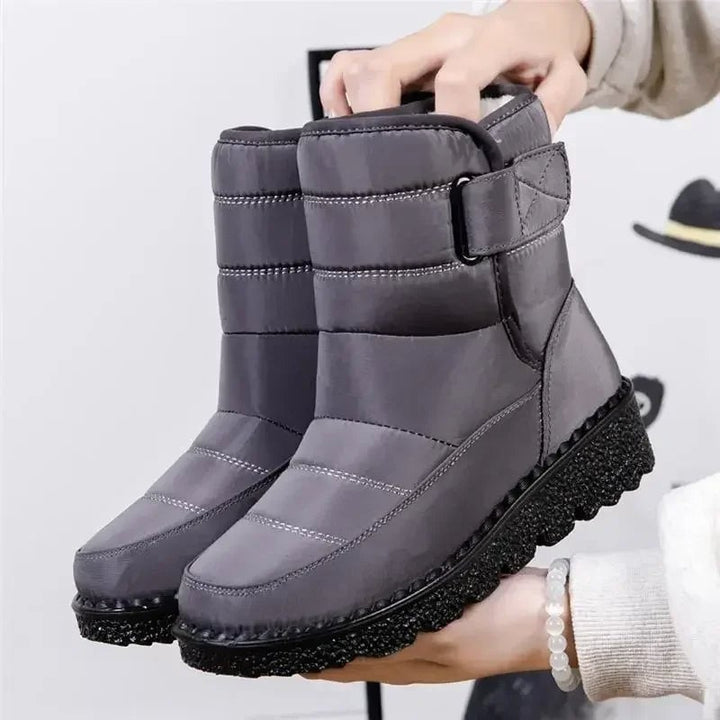 Women's waterproof boots in black displayed on a neutral background