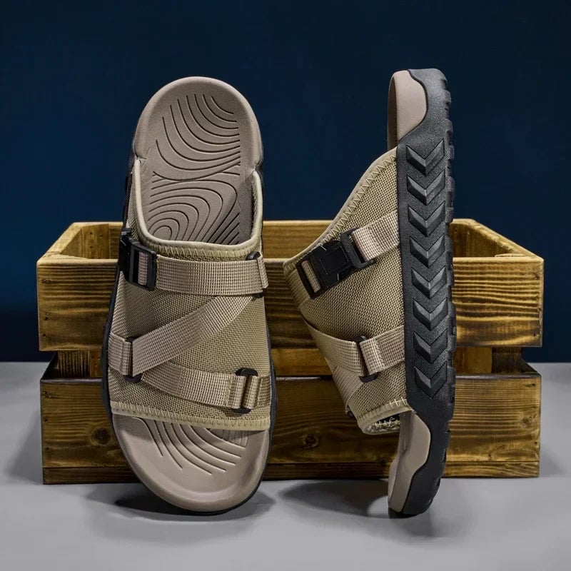 Pair of Joy slip-on slippers in khaki shown side by side from a top-down view