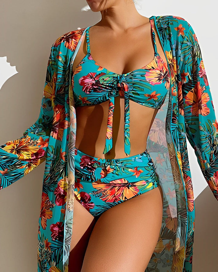 Woman walking along the shoreline wearing the tropical print bikini set with lightweight cover-up draped over shoulders