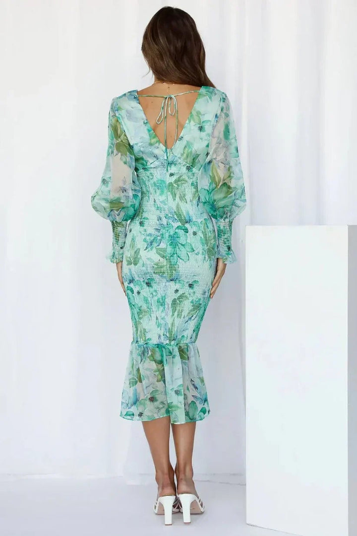 Model styled in the Julia floral dress in green with accessories for a wedding guest look