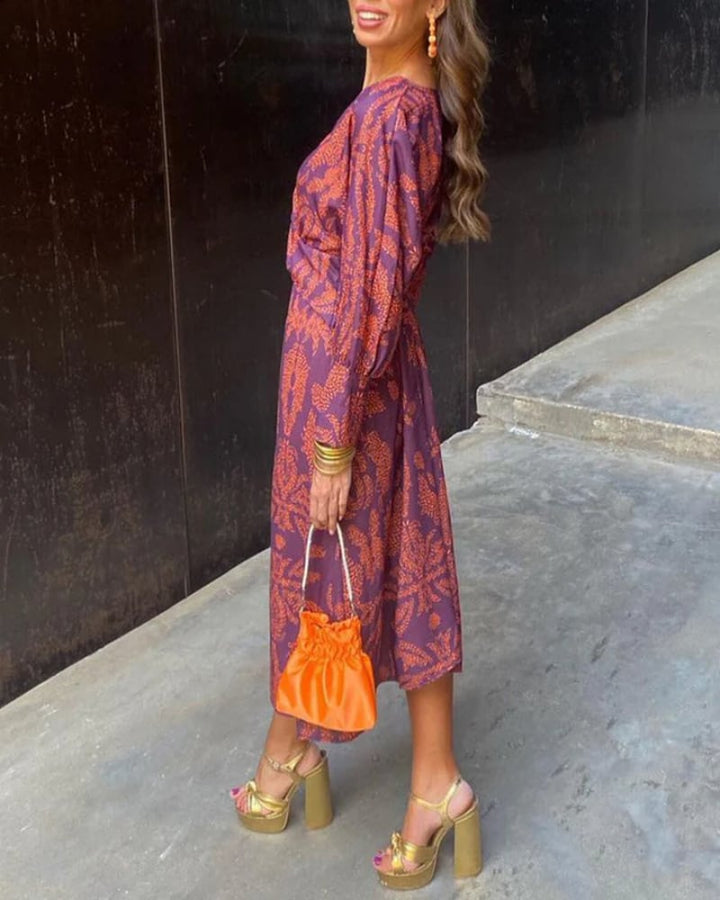 Close-up of the intricate pattern and delicate draping on a red long sleeve maxi dress