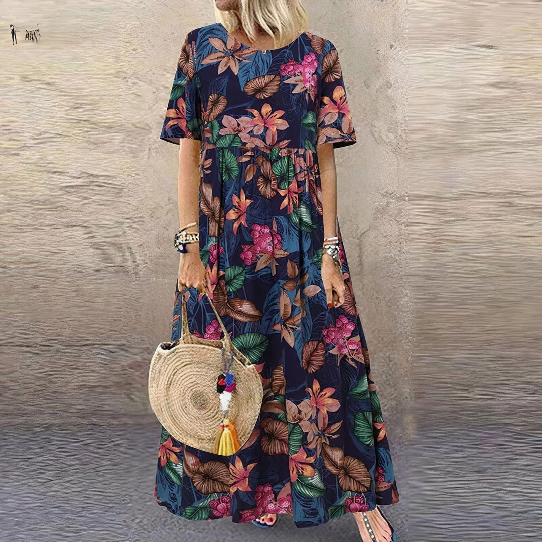 Woman wearing the Juniper floral flowy maxi dress in blue with a draped silhouette and sweeping hem