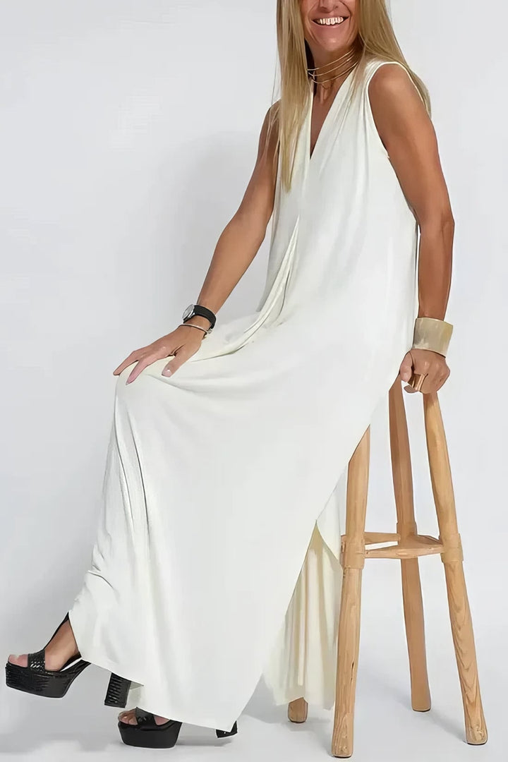 Model in a white long dress and cardigan set posing to show the flattering silhouette