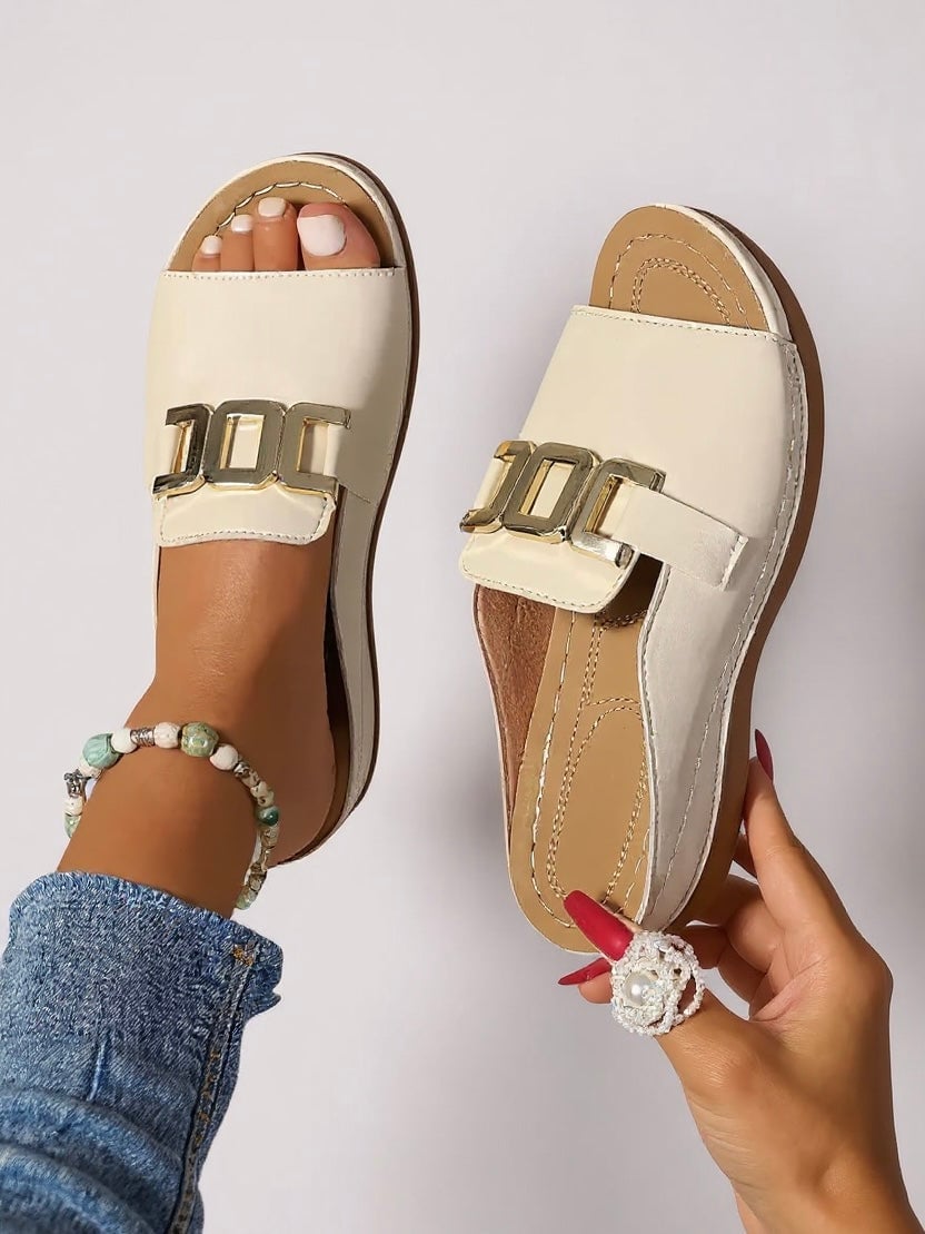 Pair of Juno slides in pink laid on a light surface showing the padded insole