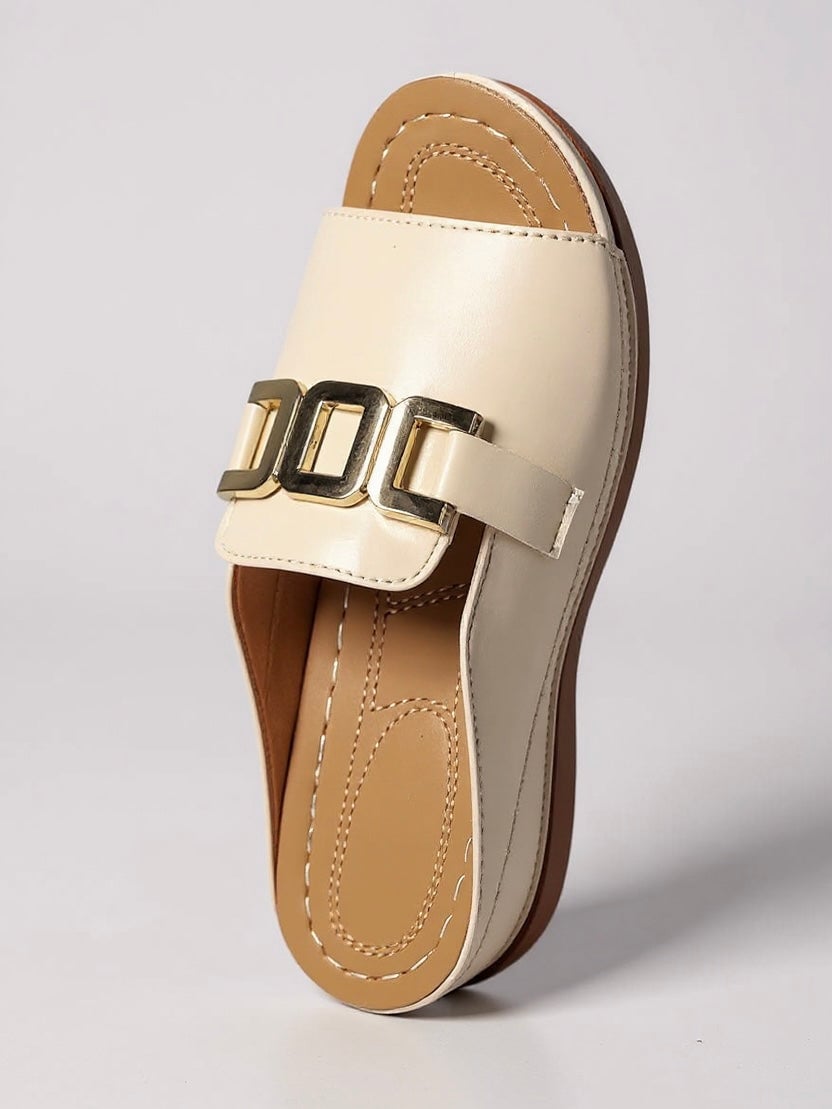 Juno slides in beige worn by a model walking on a sun-lit surface