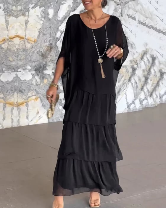 Full-length view of the long flowing dress in black showing its graceful movement