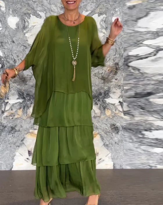 Long flowing dress in faded green color shown in a lifestyle setting