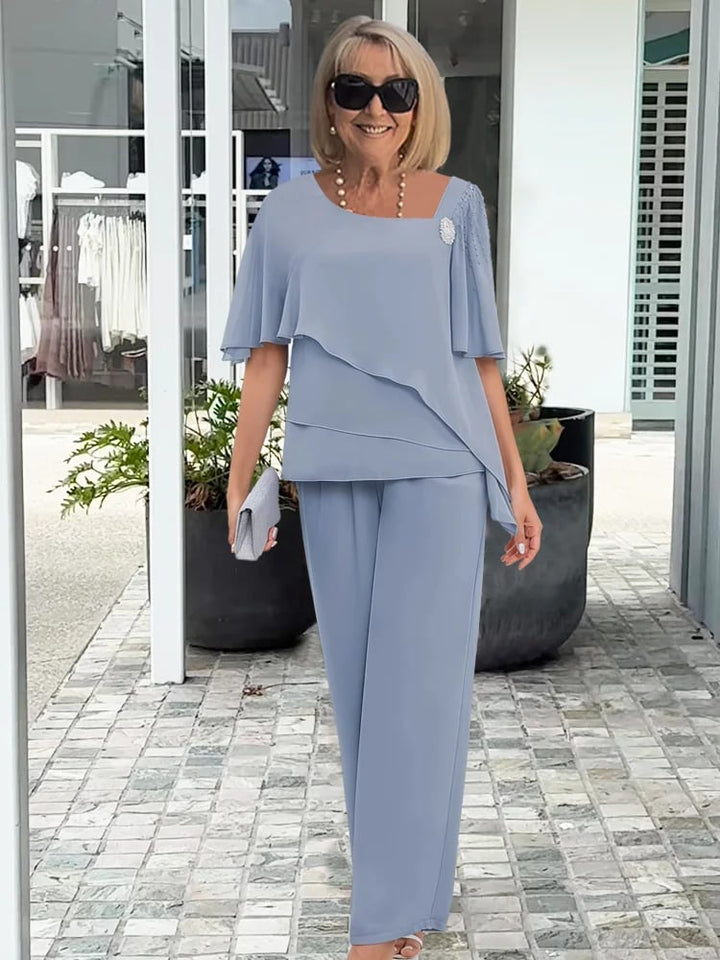Model wearing a light blue elegant two-piece flowing set with a flattering feminine silhouette