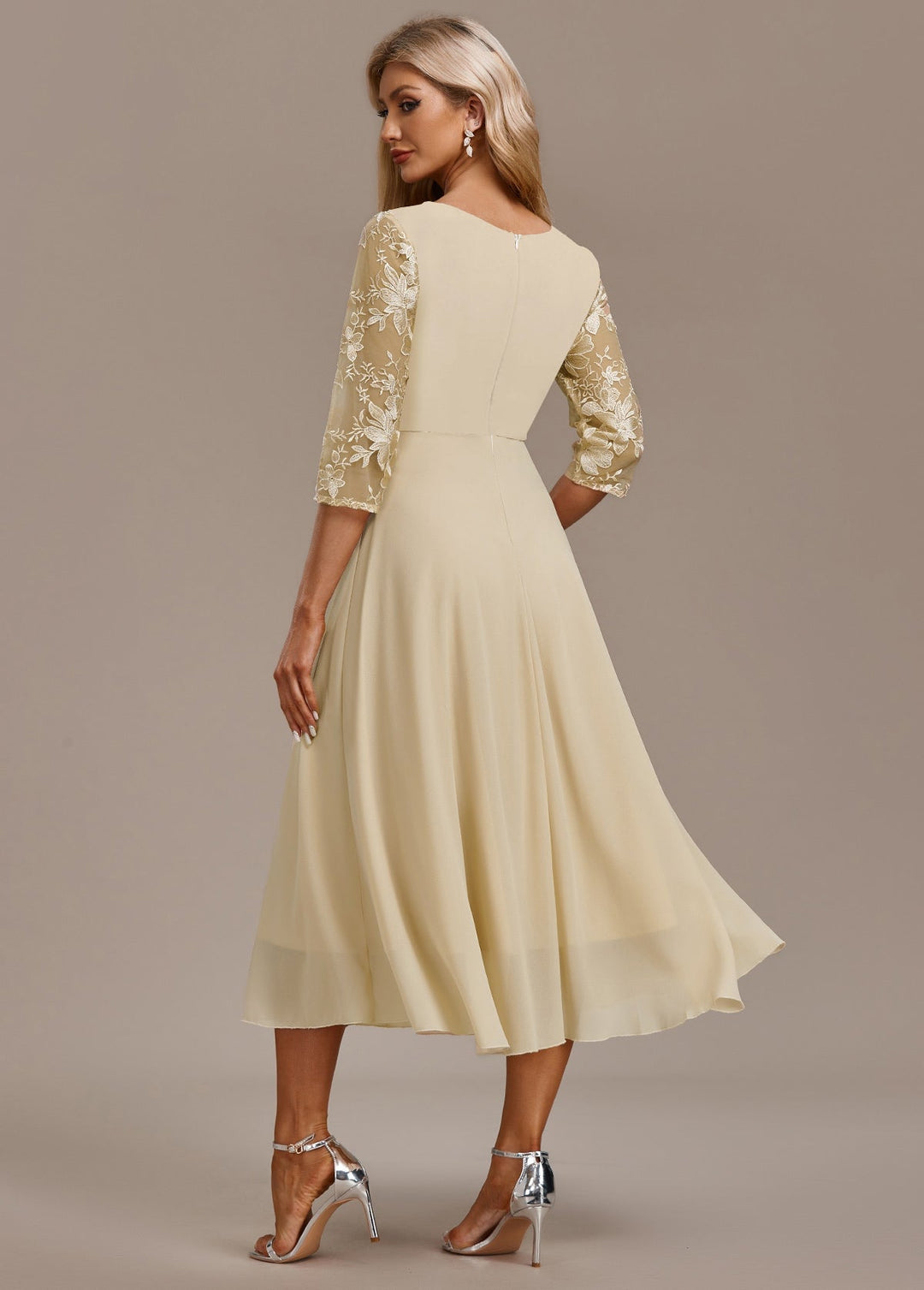Back view of champagne floral 3/4 sleeve dress highlighting round neckline and elegant drape