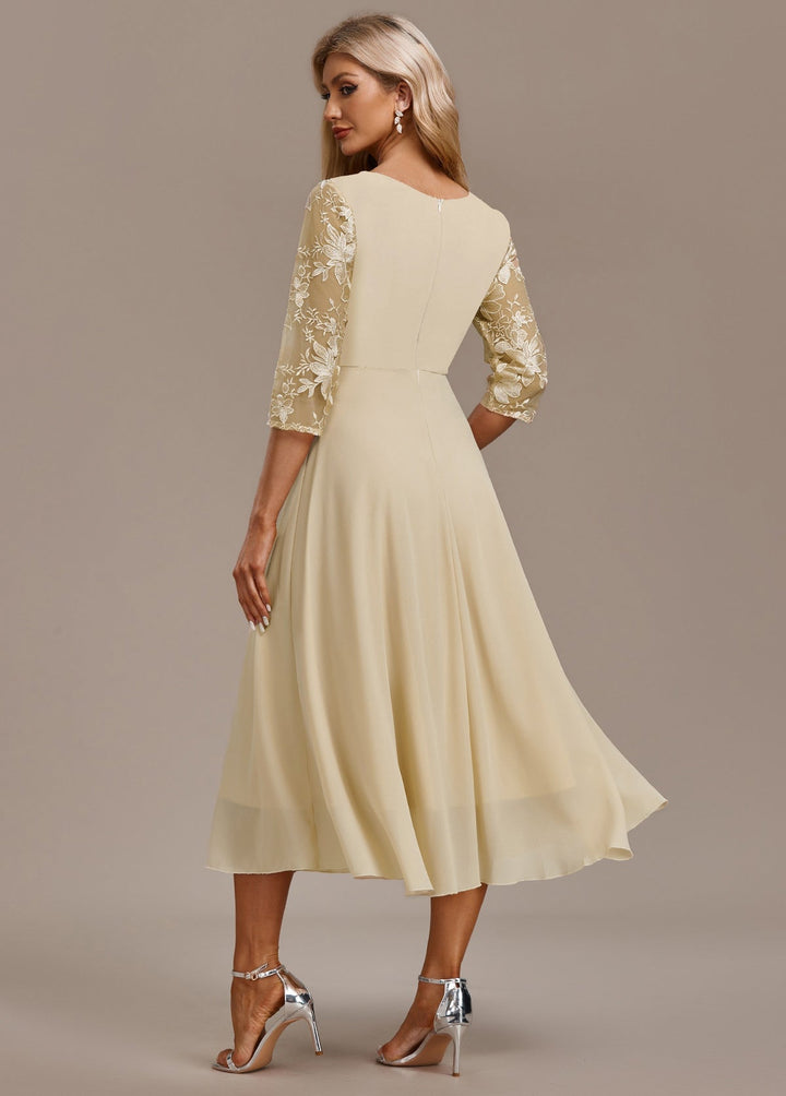 Back view of champagne floral 3/4 sleeve dress highlighting round neckline and elegant drape