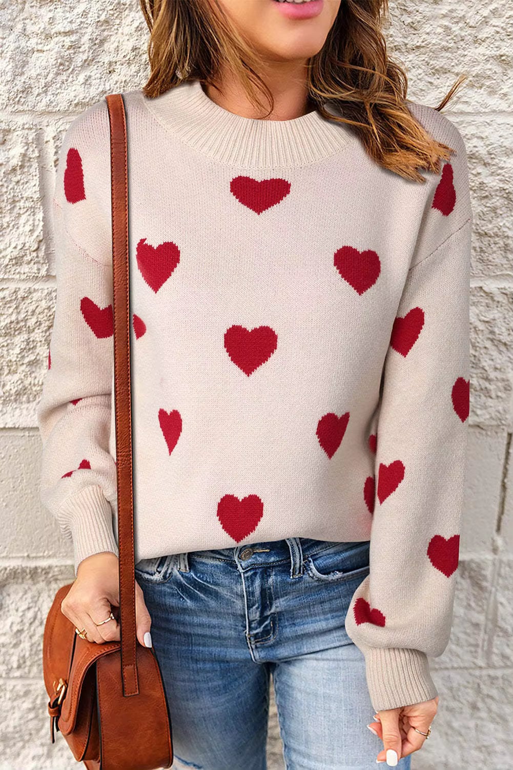 Close-up of a pink elegant hearts sweater showing delicate heart pattern and soft fabric texture