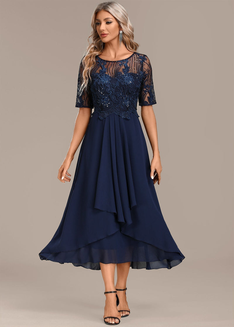 Woman wearing a navy lace short sleeve round neck dress, front view, elegant occasion style
