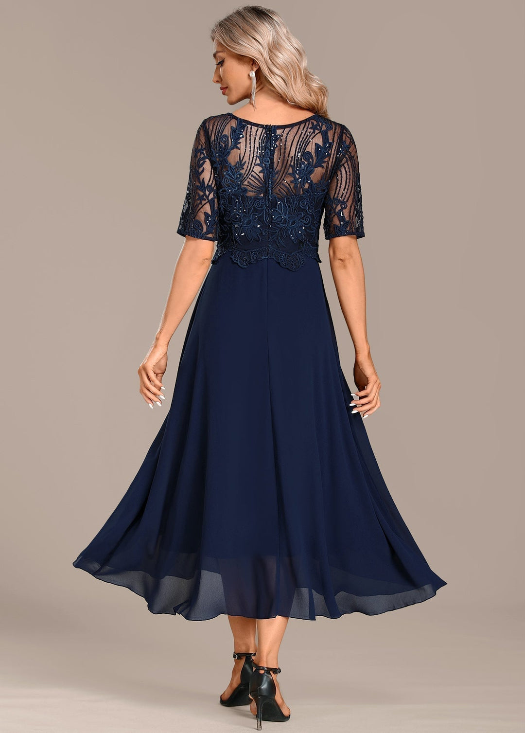 Navy lace dress shown from the side, highlighting the flattering silhouette and short sleeves