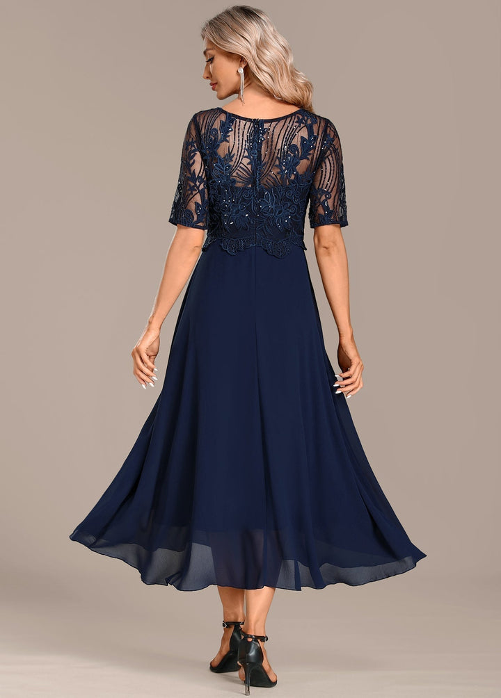 Navy lace dress shown from the side, highlighting the flattering silhouette and short sleeves
