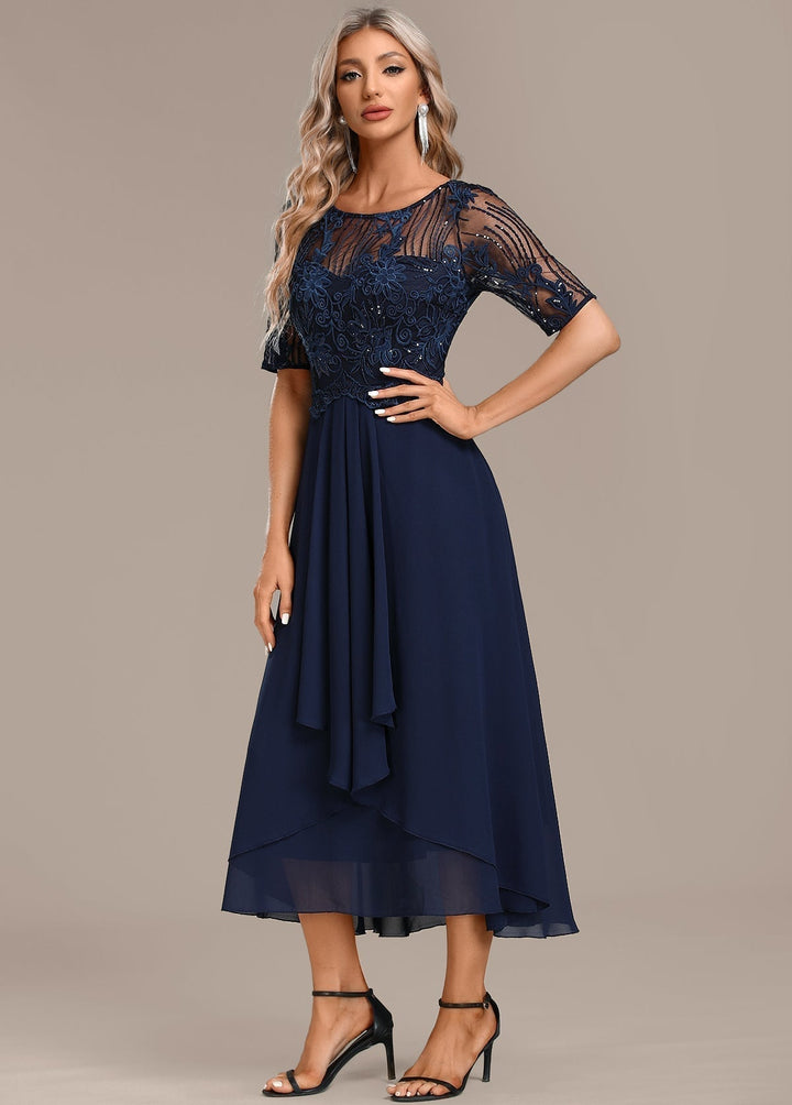 Model in a navy lace dress styled for a formal occasion, showing length and fit