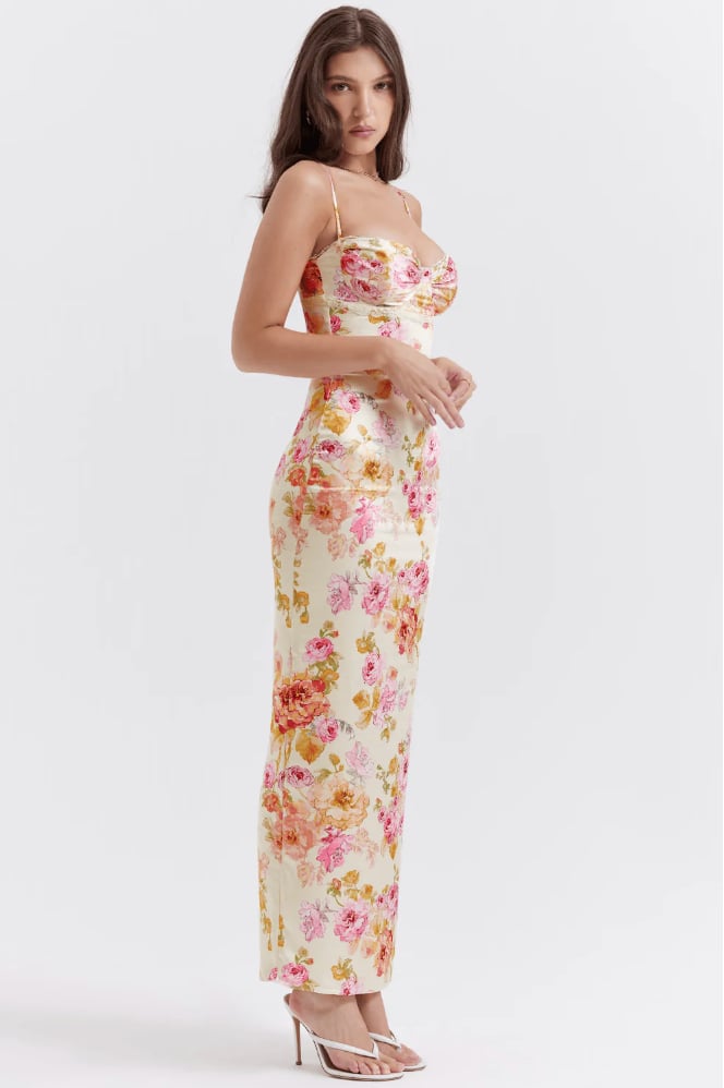 Model wearing the Katherine floral dress in a sunny outdoor setting, full-length view