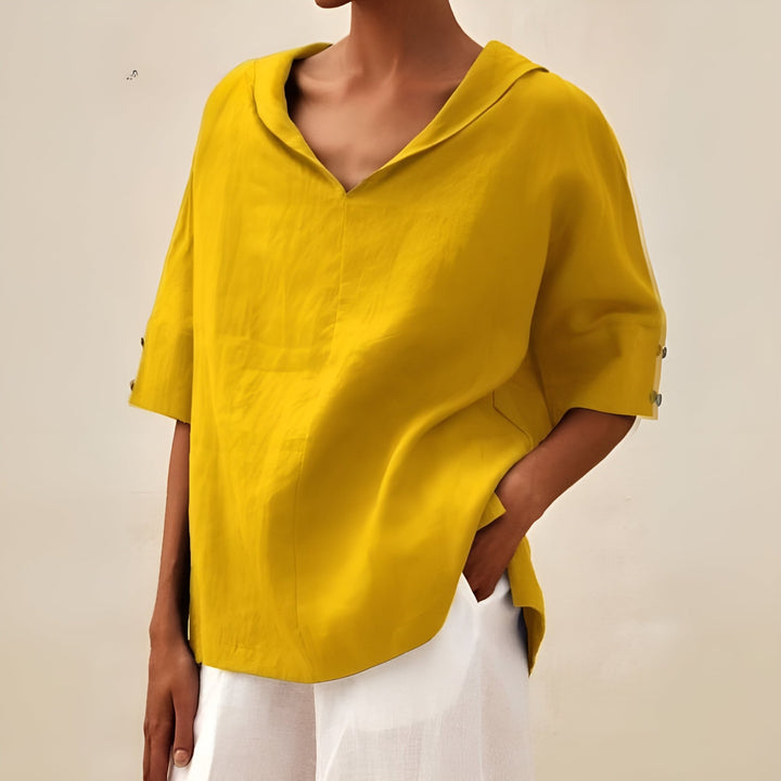 Model wearing the blouse tucked into tailored trousers for a polished daytime look