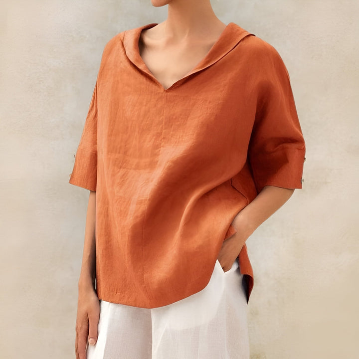 Flatlay of the Kathleen blouse in multiple color options including white, black, and green