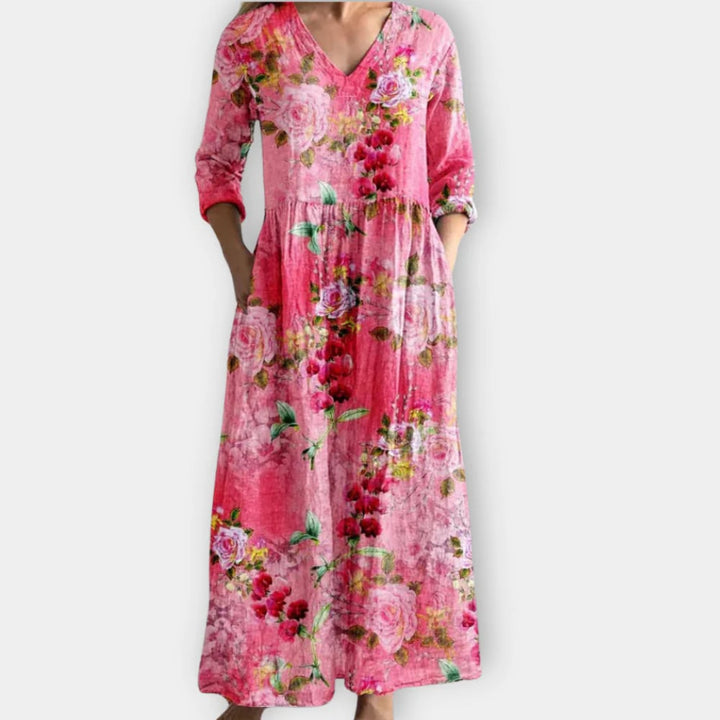 Close-up detail of pink floral print fabric on a v-neck maxi dress showing pattern and texture