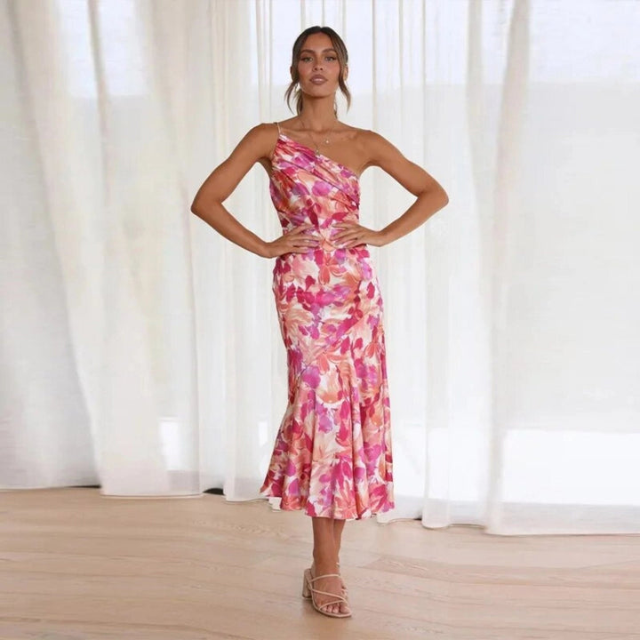 Detail shot of the asymmetrical hemline on a floral one-shoulder maxi dress