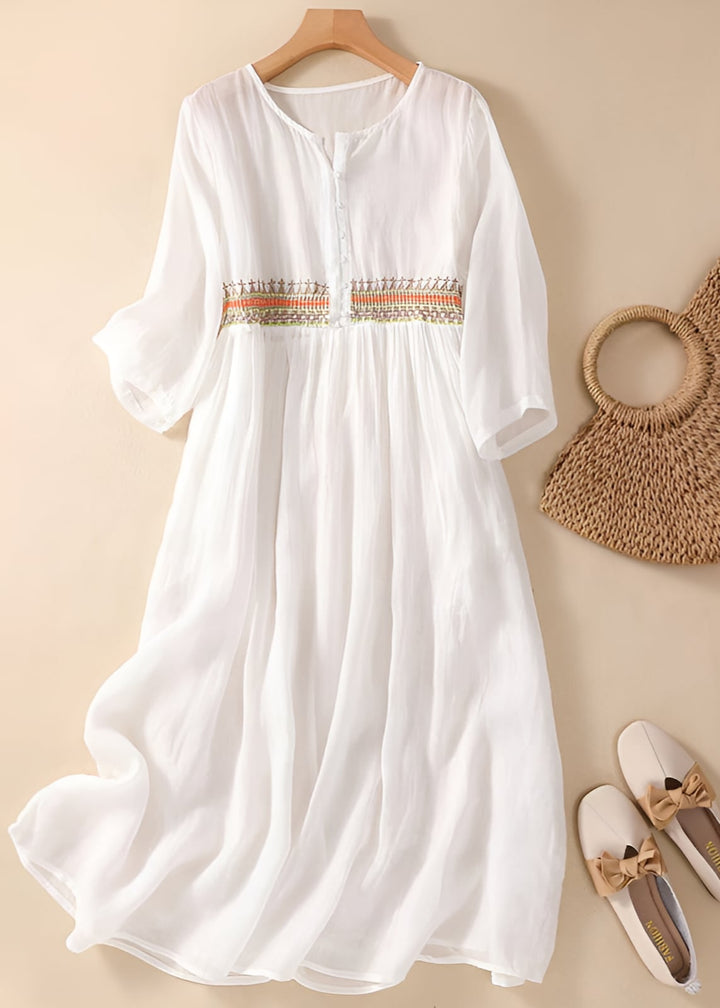 Woman wearing a white embroidered pattern midi dress with a flowing silhouette, front view